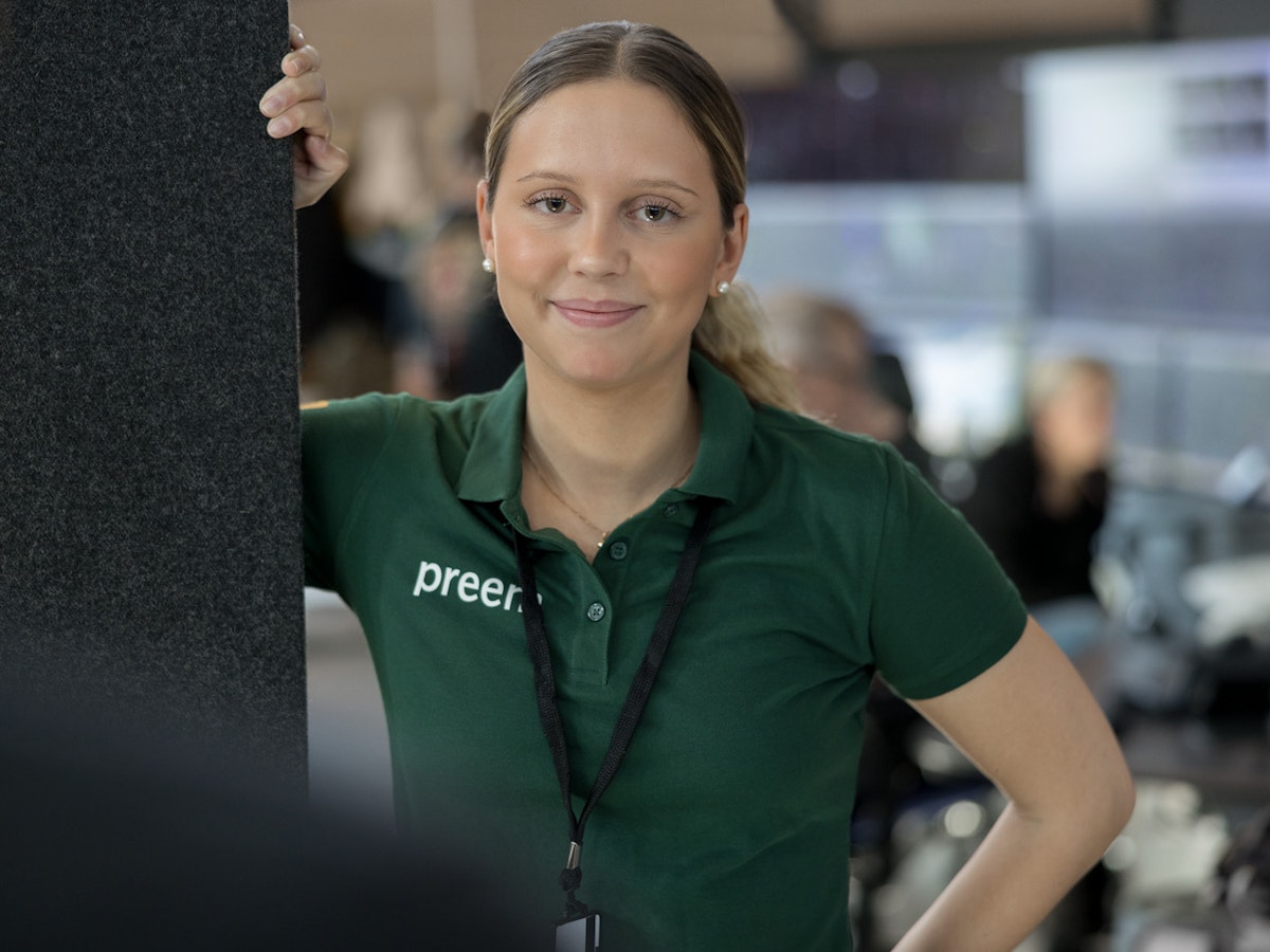 Kvinnlig Preem-anställd i en grön piké med Preem-logga