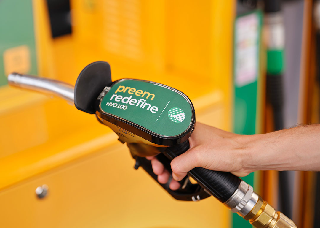 Hand håller i en tankpump med Preem Redefine HVO100
