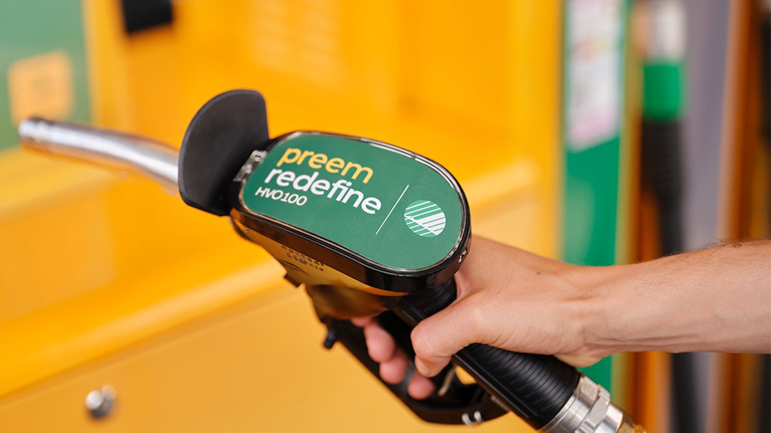 Hand håller i en tankpump med Preem Redefine HVO100