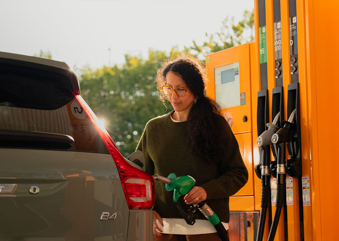 Kvinna tankar bil på en station