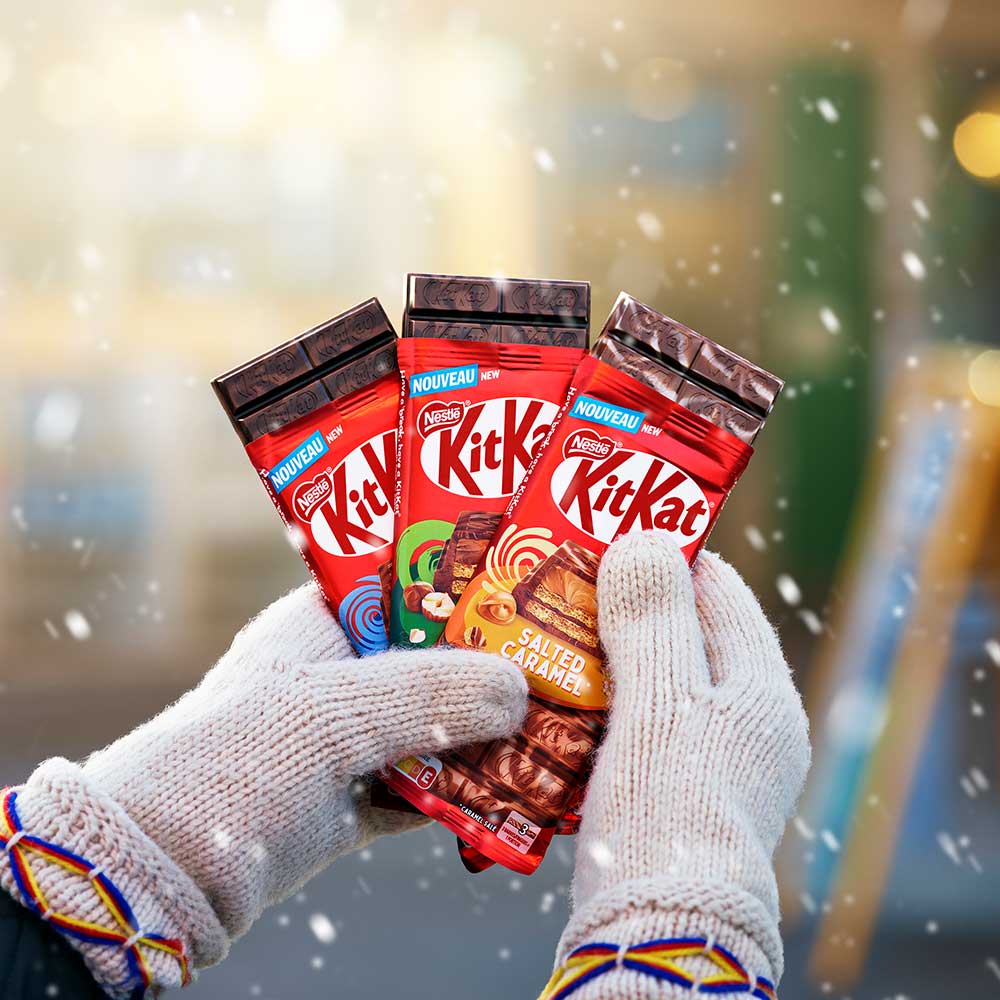 Person med vantar håller i KitKat