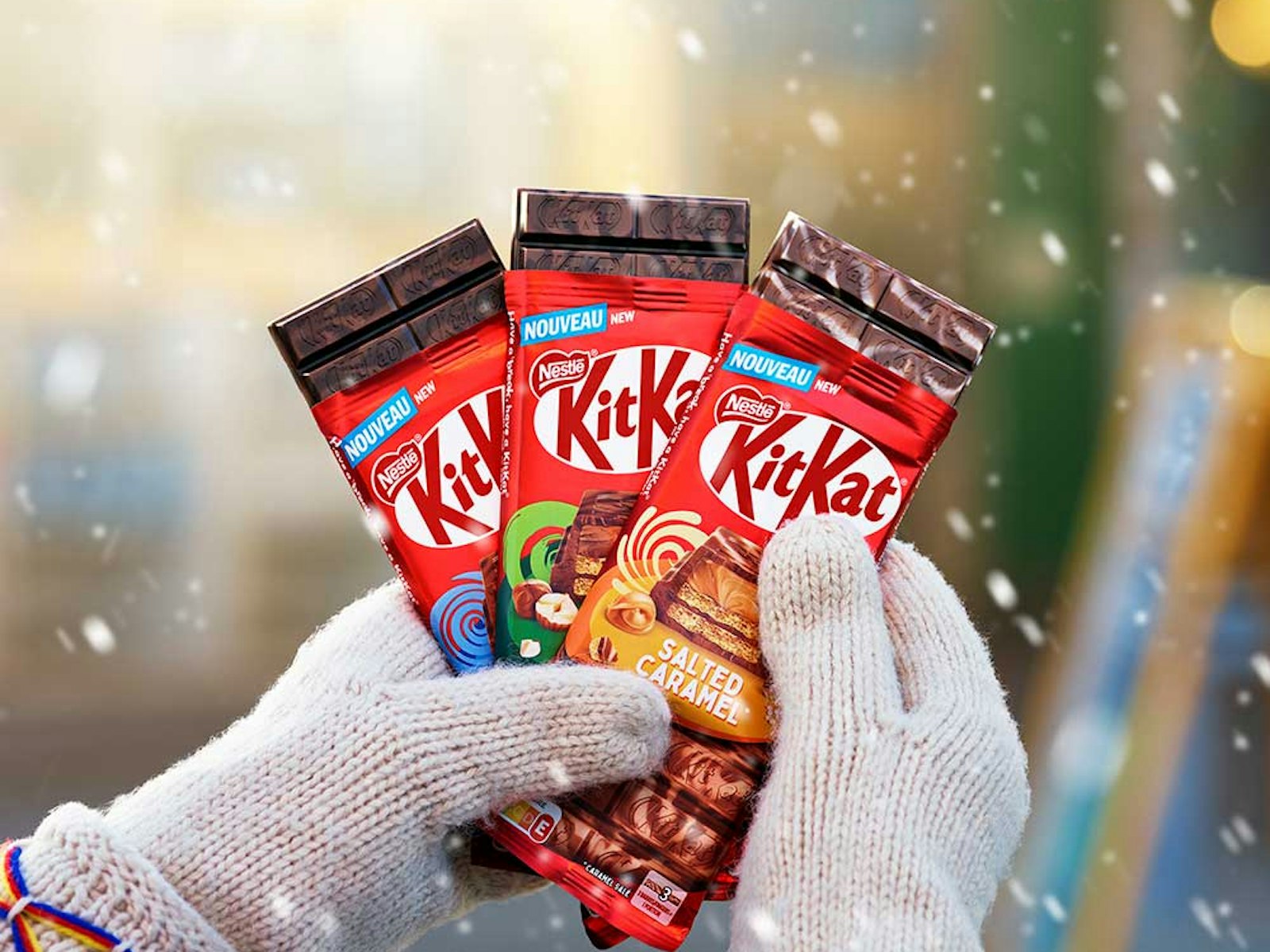 Person med vantar håller i KitKat