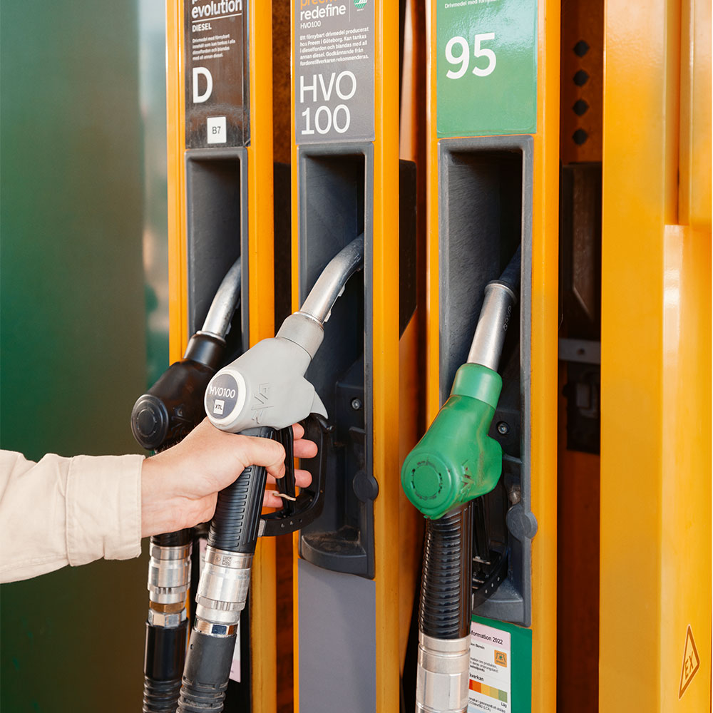 En person håller i ett pumphandtag på station