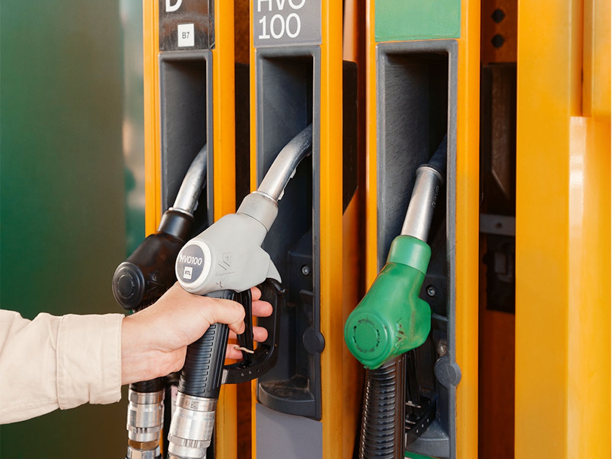 En person håller i ett pumphandtag på station