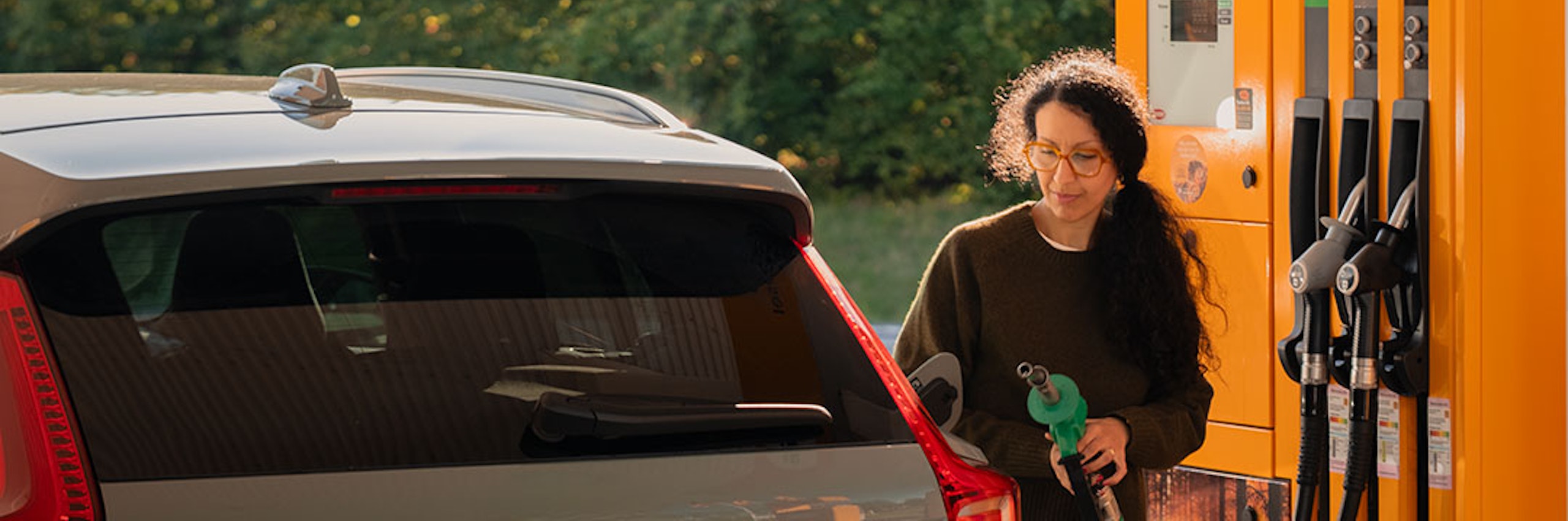 Kvinna tankar bil på en station