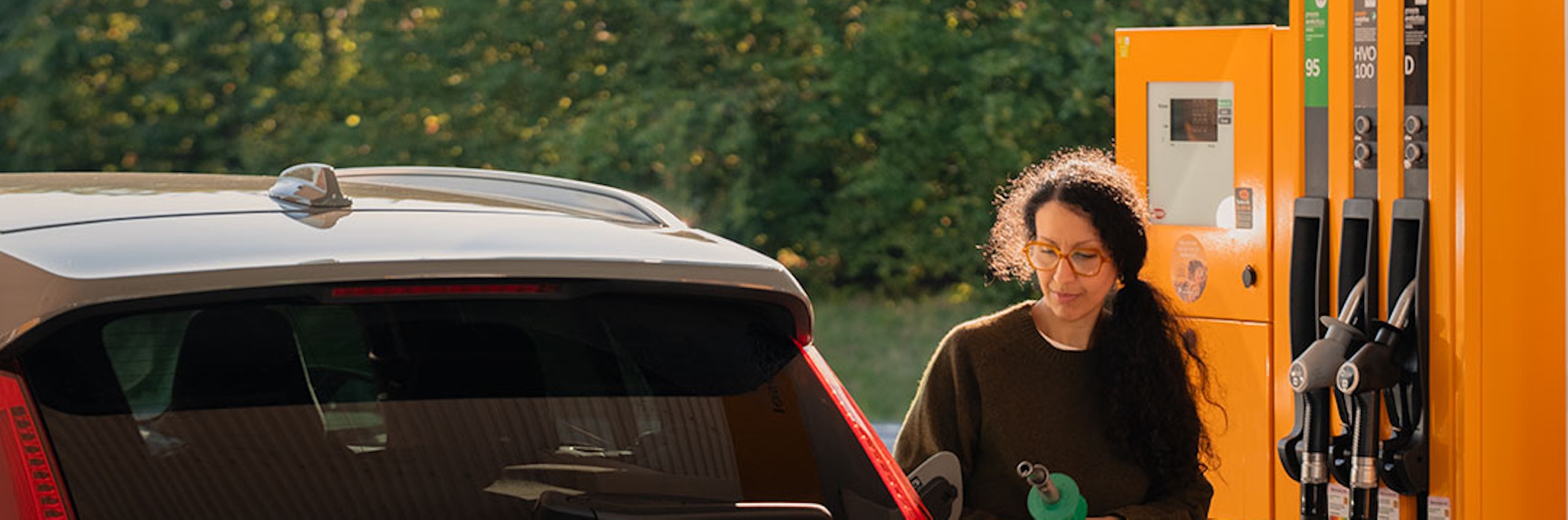 Kvinna tankar bil på en station