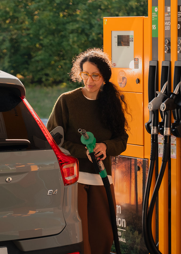 Kvinna tankar bil på en station