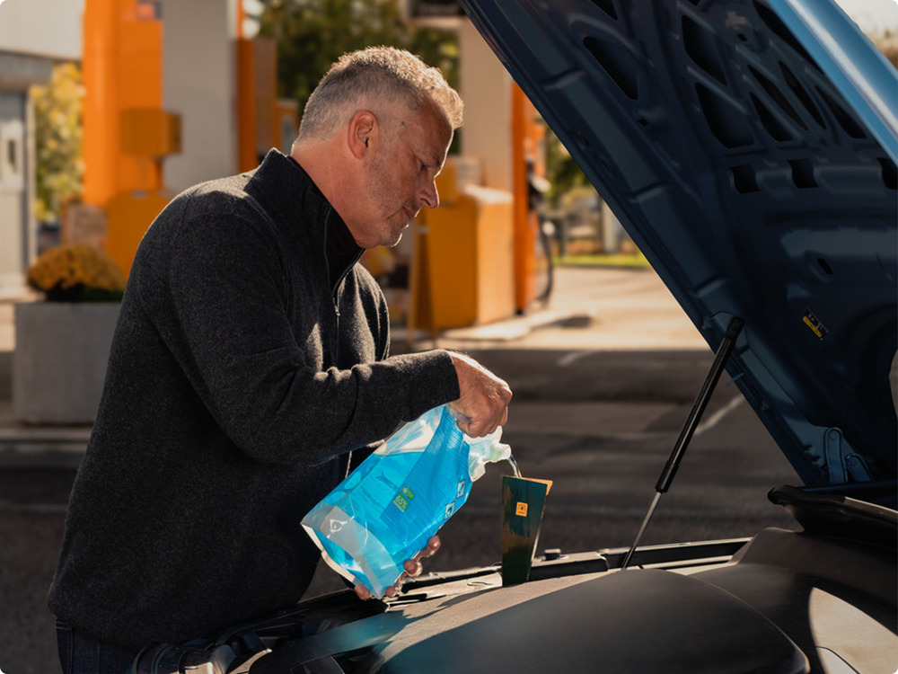 Man fyller på med spolarvätska