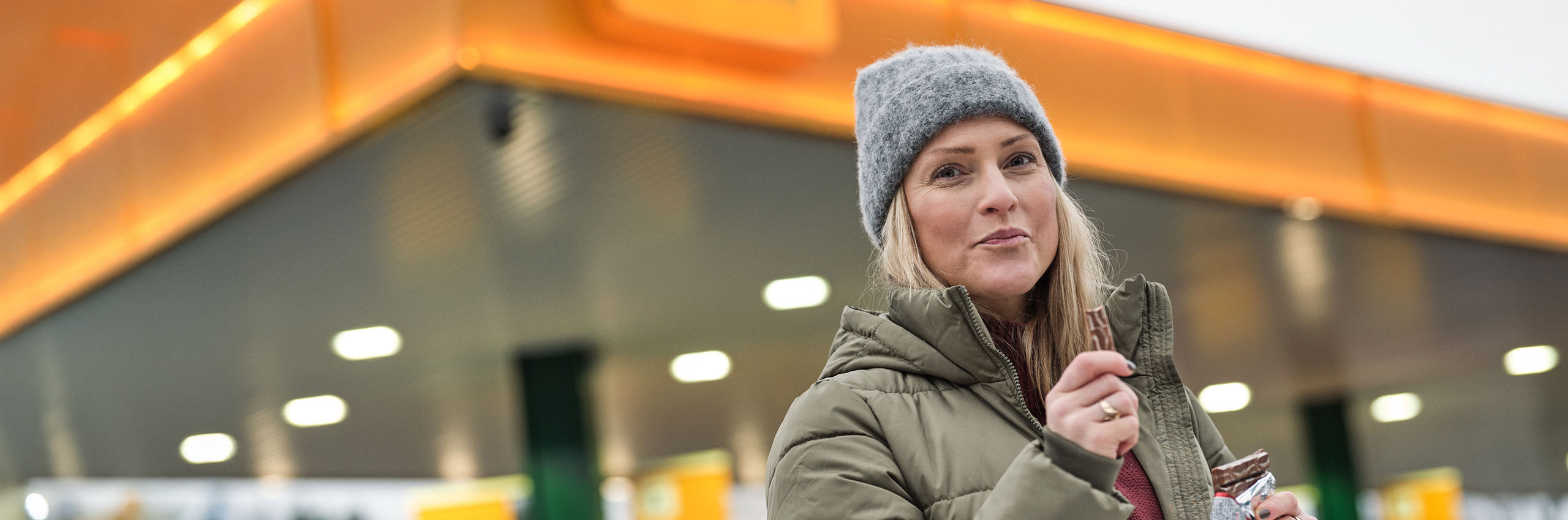 Kvinna står på station och håller i en KitKat