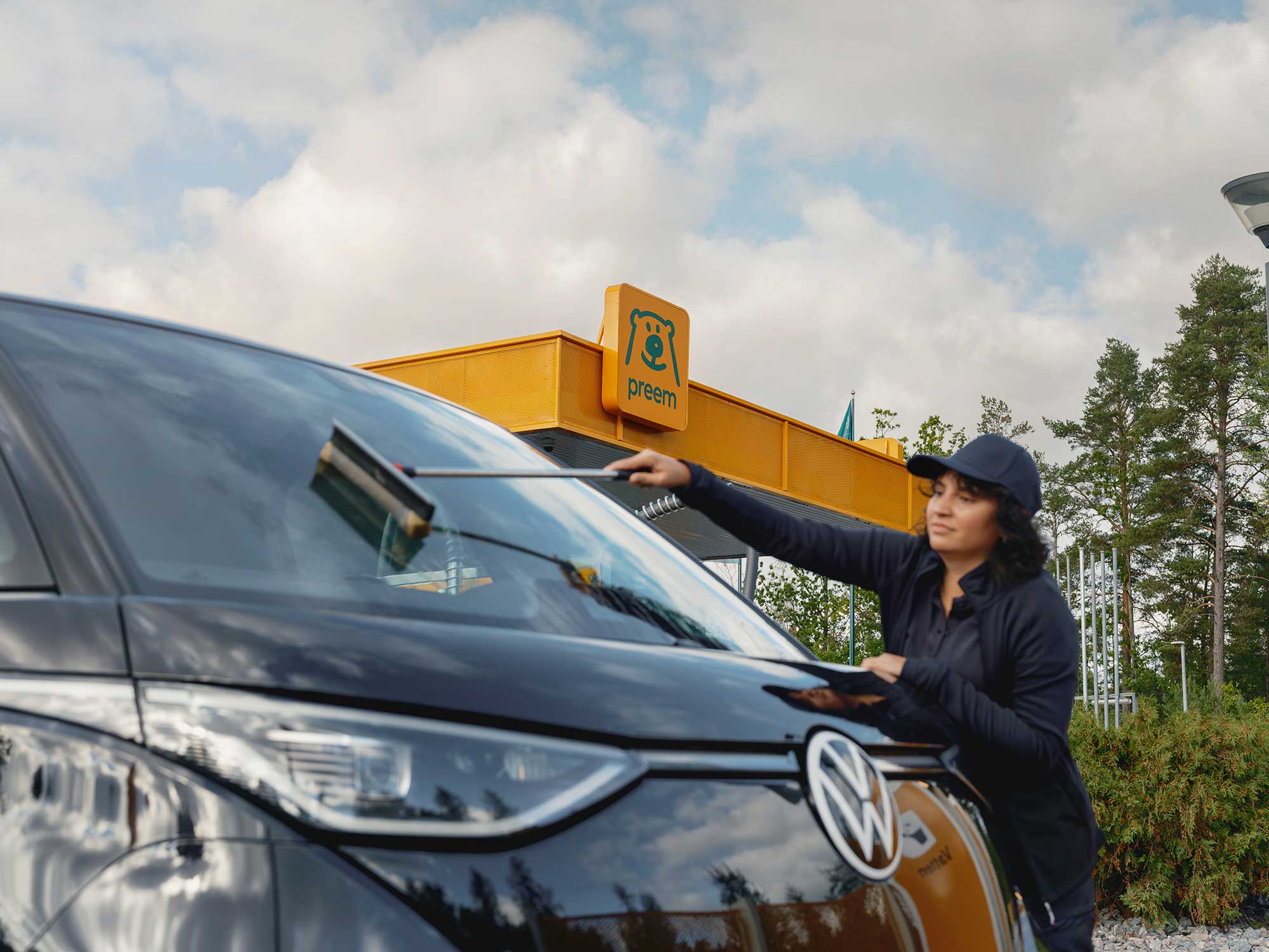 En kvinna tvättar bilruta.