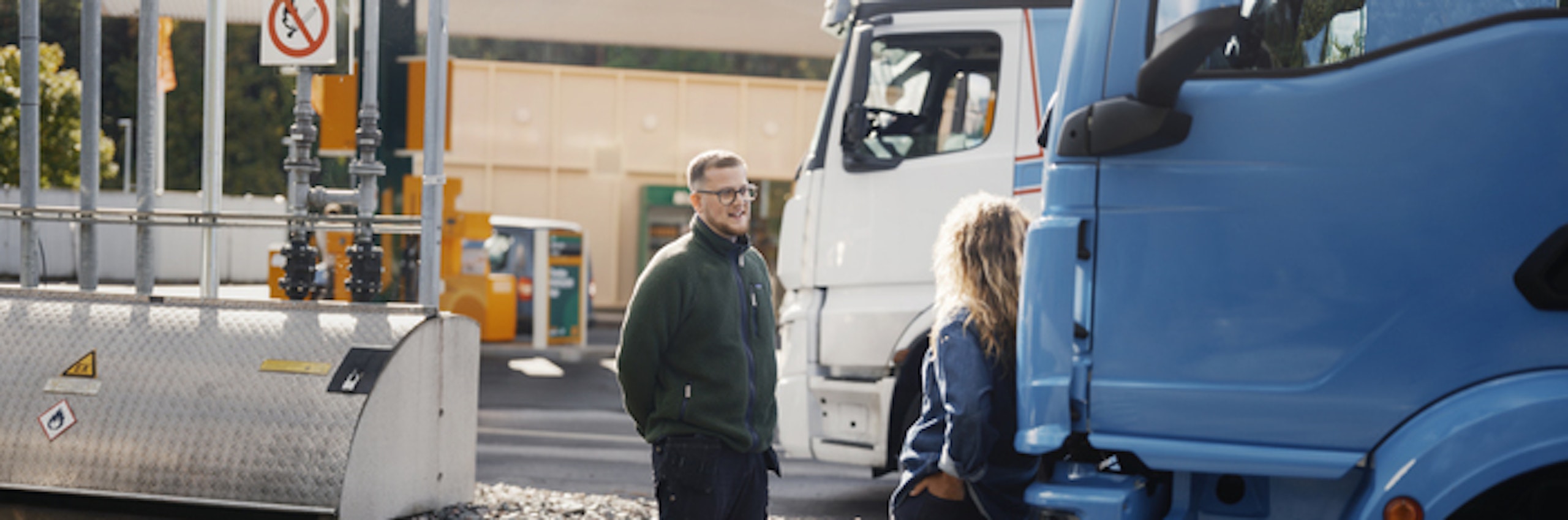 Man och kvinna står vid trucks och konverserar