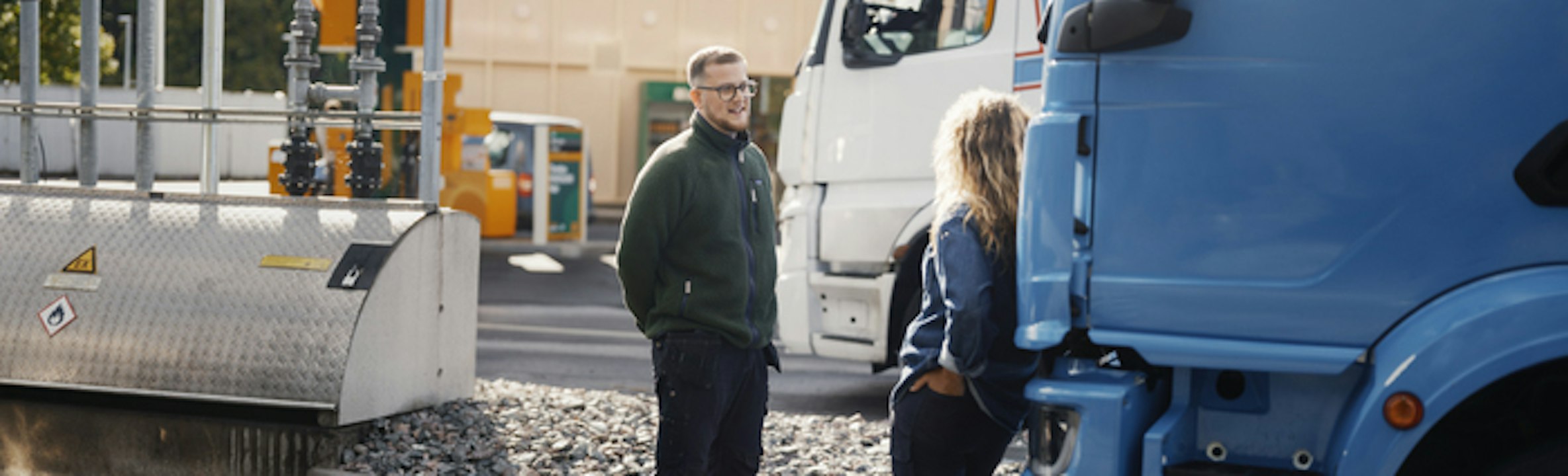Man och kvinna står vid trucks och konverserar