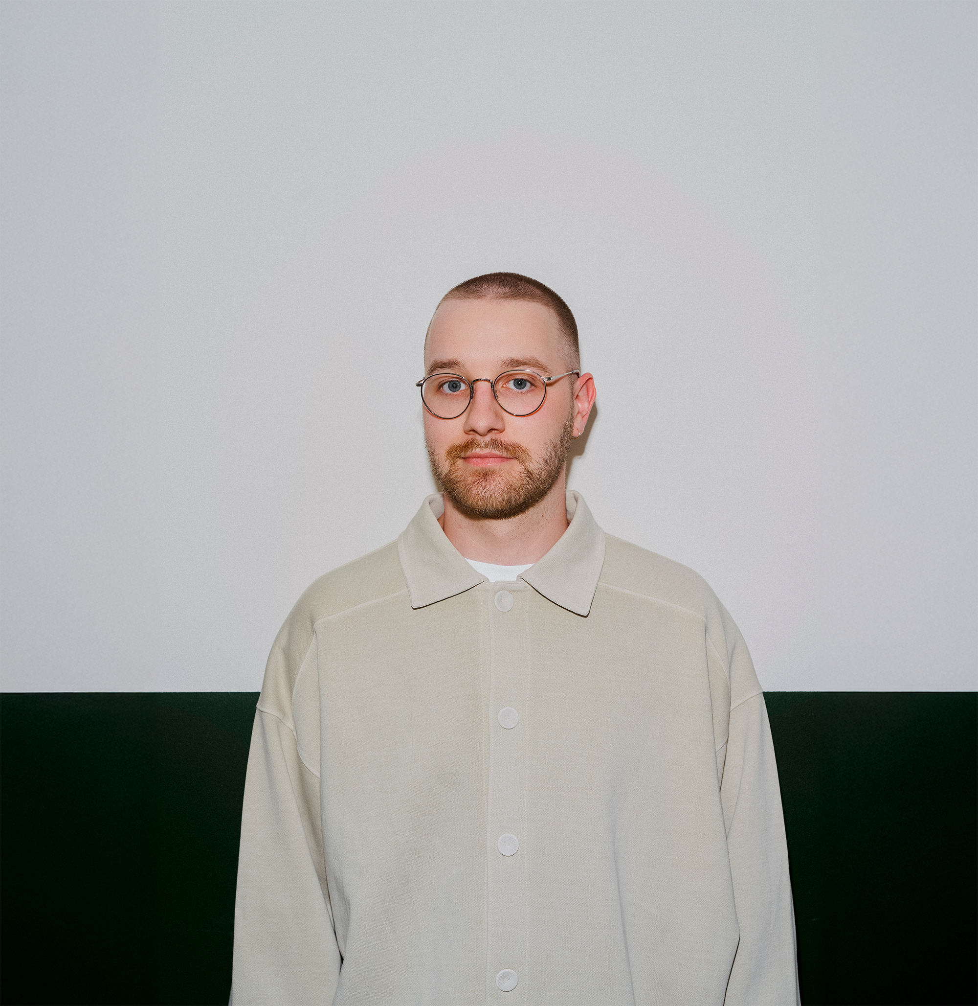 Portrait of Deven, co-founder of Domaine Public, wearing a cream corduroy jacket