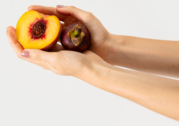 person holding a peach
