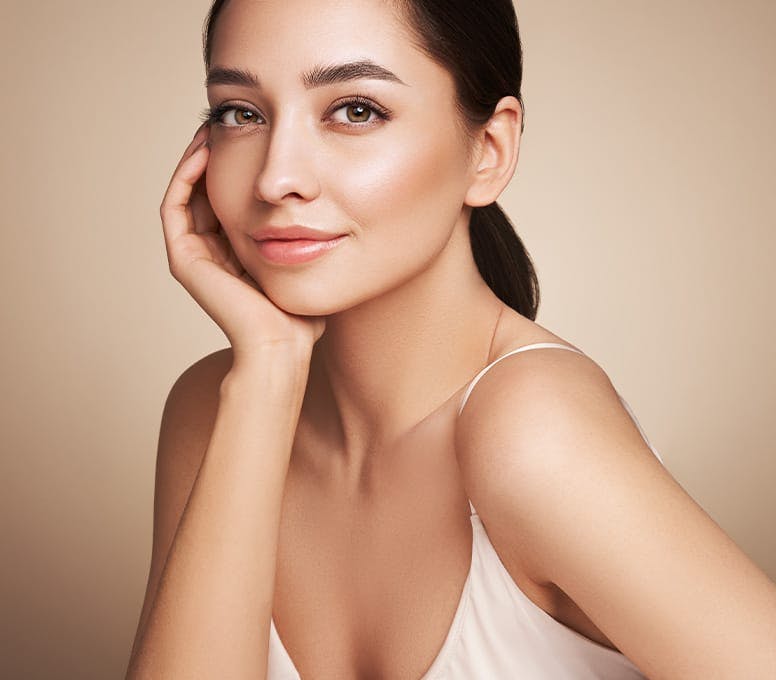 woman in white tanktop resting chin in her palm