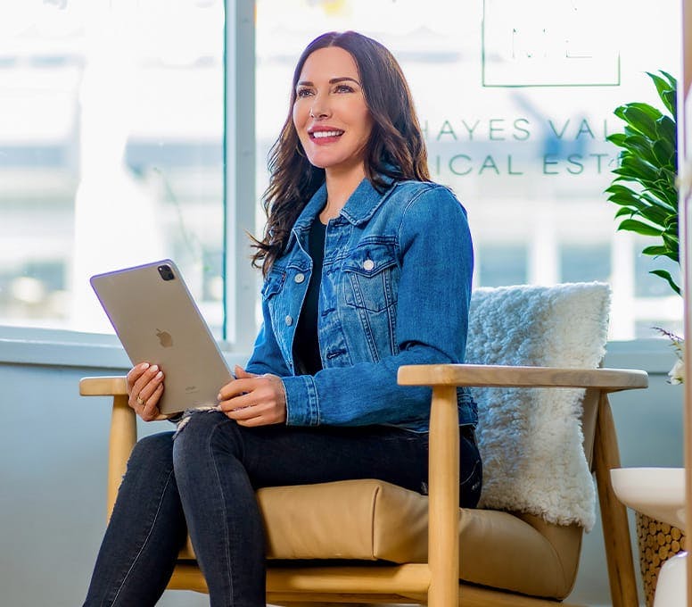 woman in jean jacket holding ipad