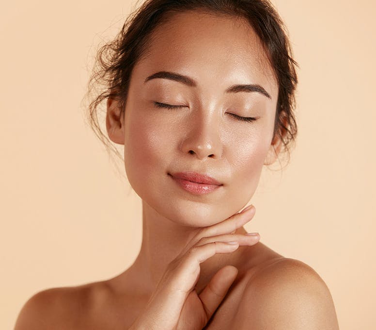 woman with her eyes closed and her hand placed under her jaw