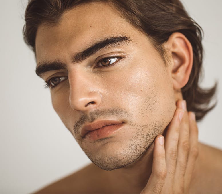 man looking to the left touching his own neck
