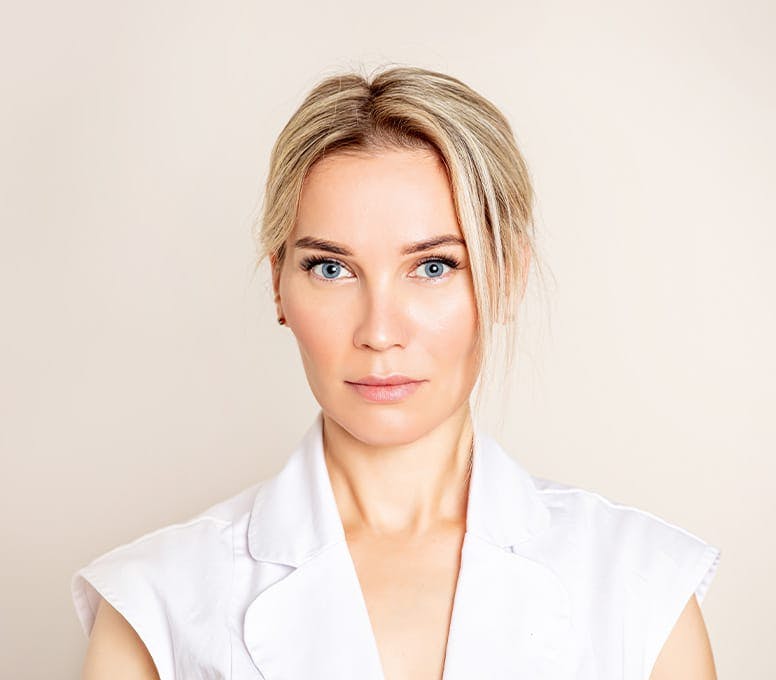 woman in white top with hair tied up