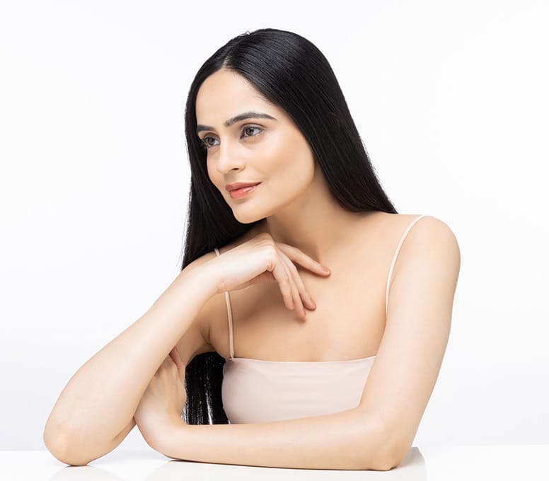 woman leaning on table with her hand cuffing her bicep