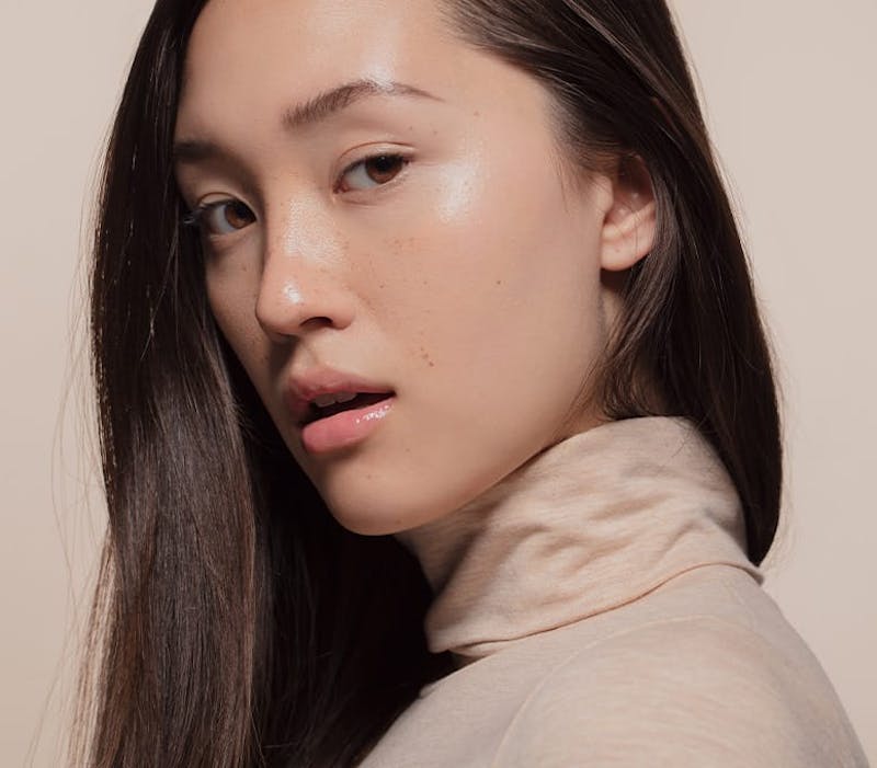 woman in beige sweater looking over her shoulder
