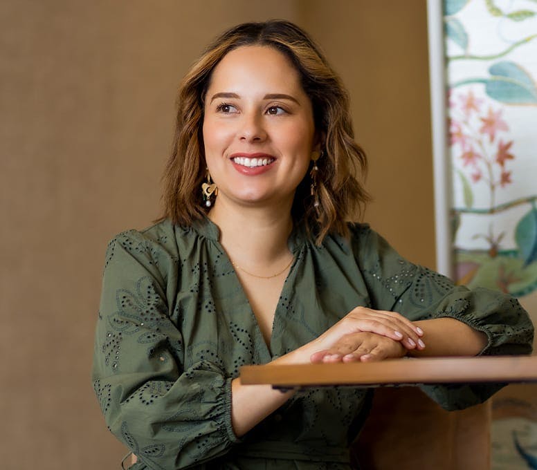 woman smiling with her hands on a table