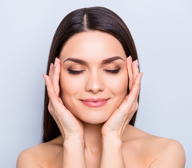 woman with her eyes closed with her hands on her temples
