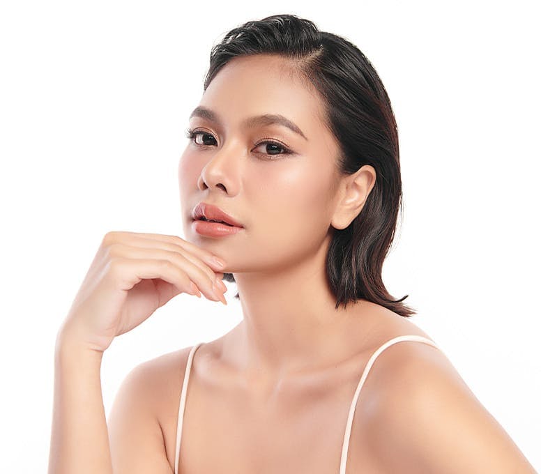woman with short hair and hand touching her chin