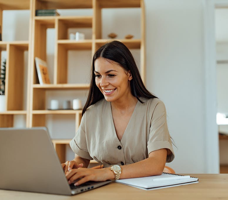 woman smiling and looking on laptop