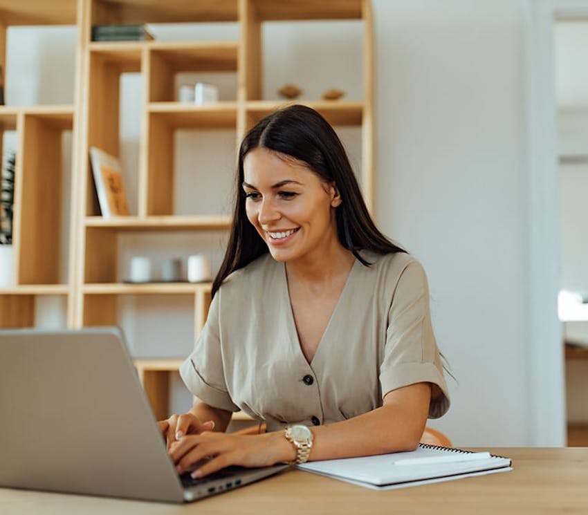 woman smiling and looking on laptop