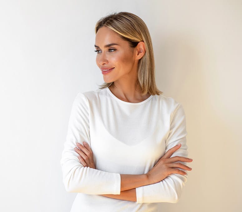 woman with her arms crossed in white top