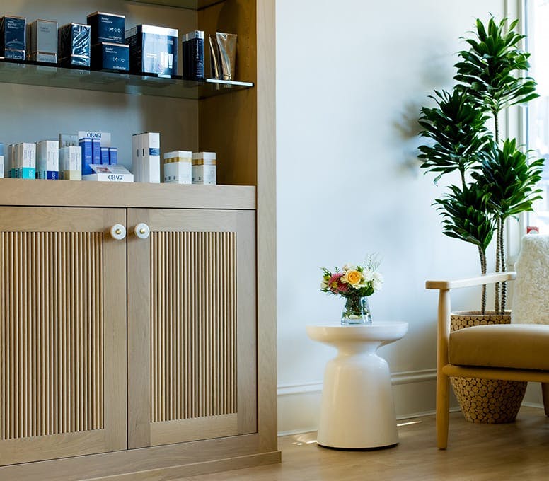 shelf with skincare products next to an end table and chair