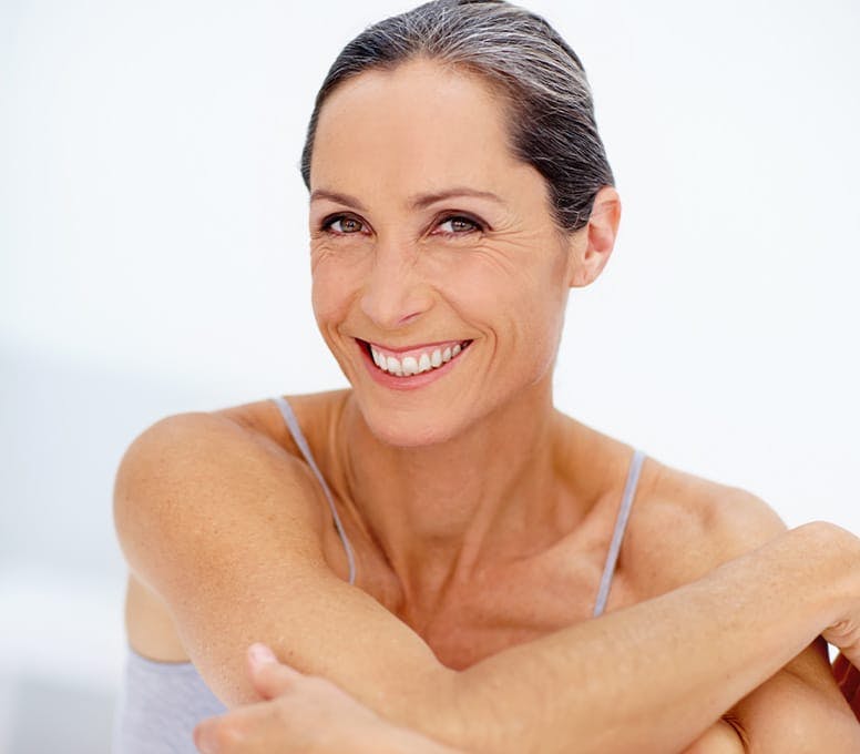 woman hugging her knees and smiling