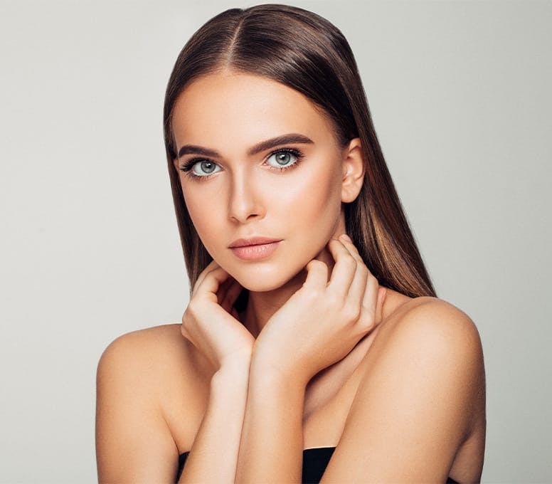 woman with straight hair cuffing her neck with her hands