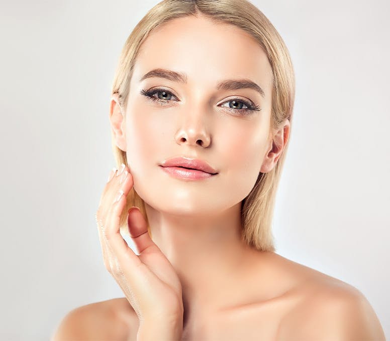blonde woman with short hair with hand near her ear