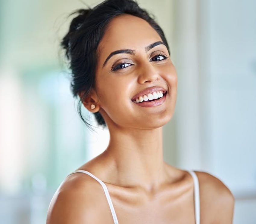 woman with hair tied up smiling