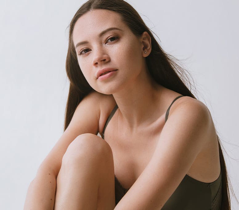 woman sitting with arms around her bent leg