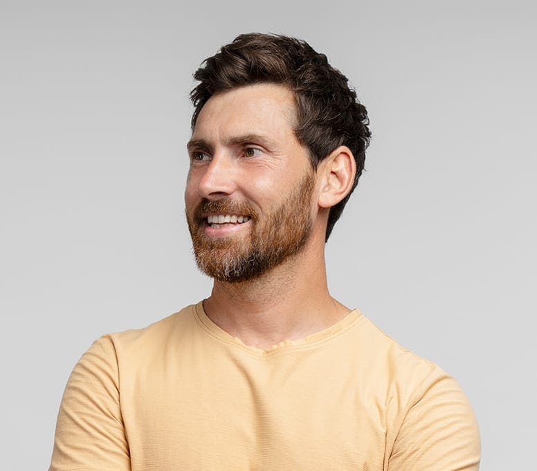 man in yellow shirt smiling and looking to the left