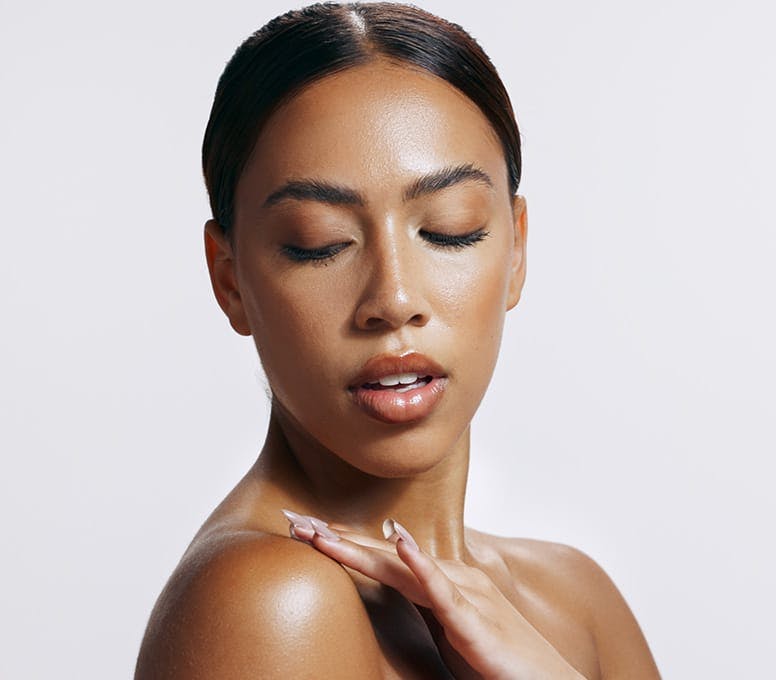 woman looking at her shoulder and touching it with her fingers