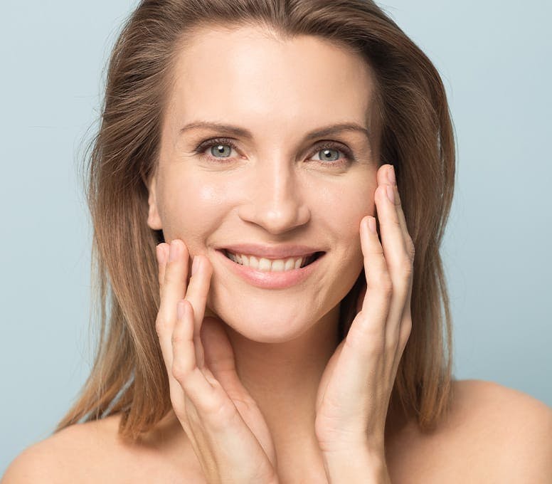 woman touching her face and smiling