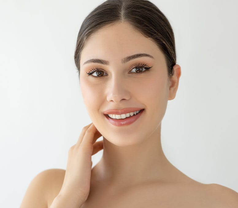 woman smiling with her hand touching her neck