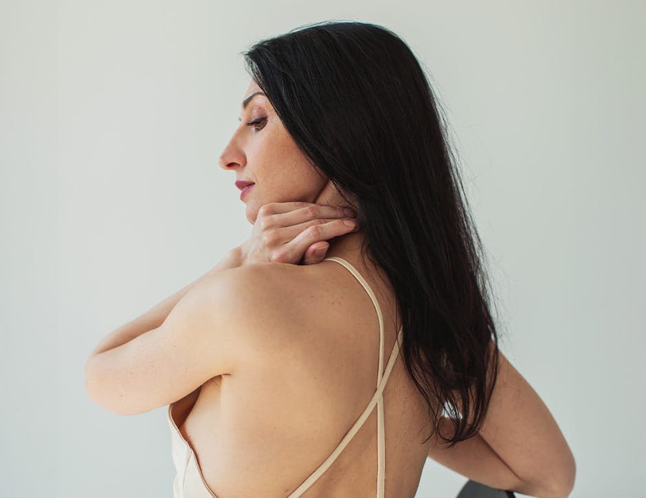 woman's back with her hand on her neck