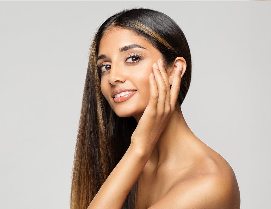 woman touching her cheekbone with hair thrown to one side of her head