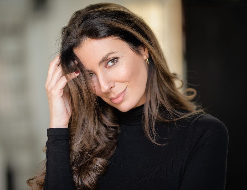 woman in black turtleneck with hair in front of her face