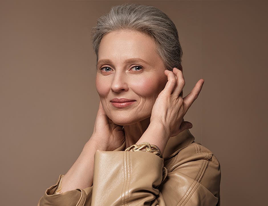 woman with gray hair in a brown jacket