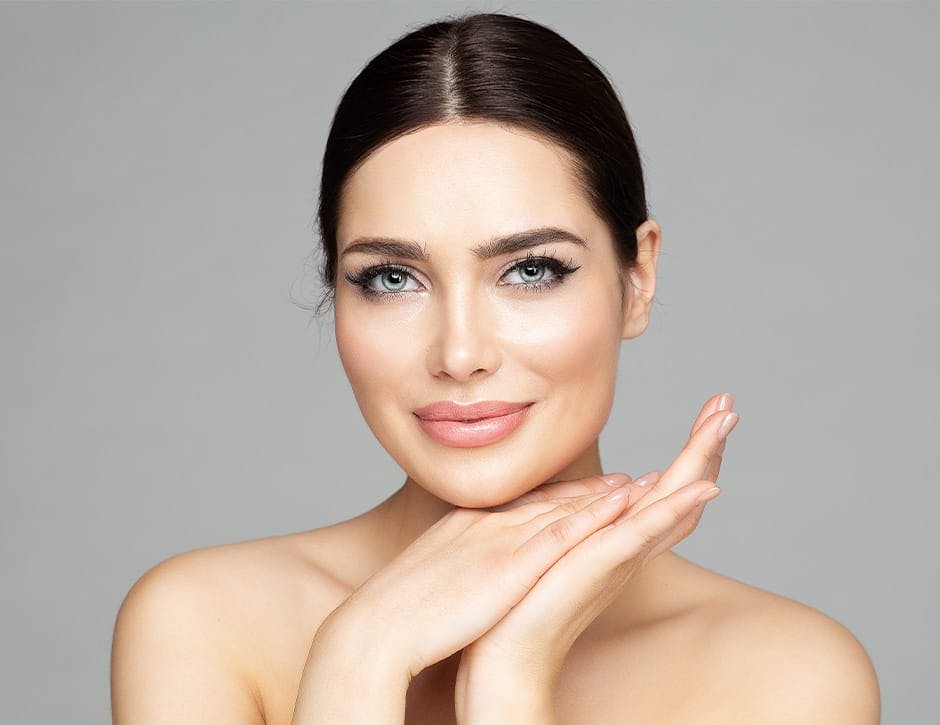 woman with her hair tied up and hands touching together