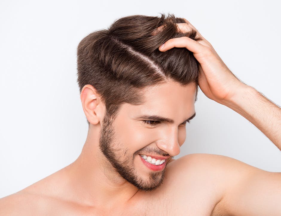 man smiling and touching his hair