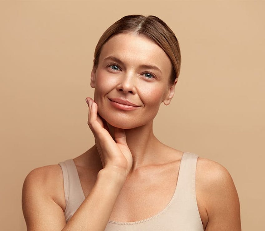 woman smiling with hand under her jaw