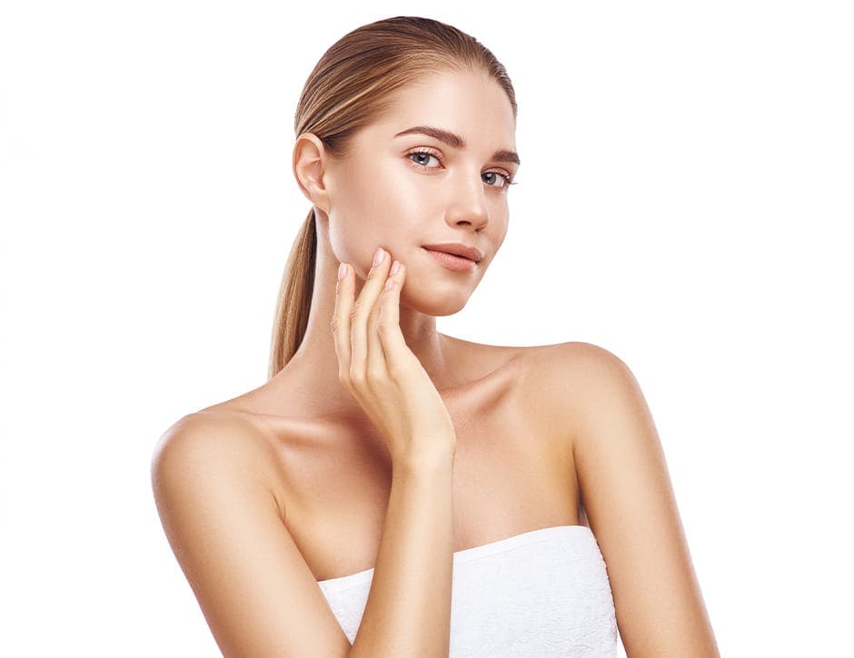 woman with towel on touching her face