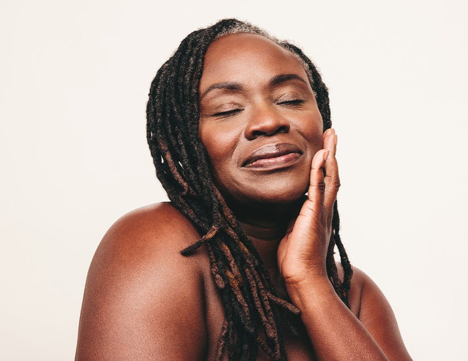 woman with her eyes closed touching her cheek